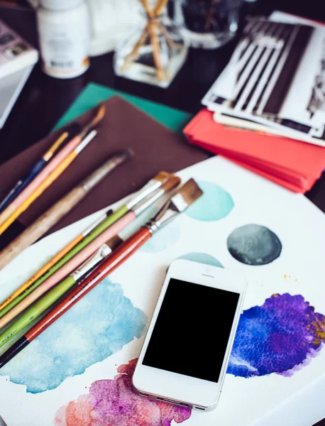 Smartphone on a table in the artist studio — Stock Photo, Image