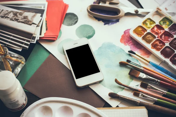 Smartphone on a table in the artist studio — Stock Photo, Image