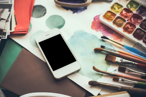 Smartphone su un tavolo nello studio dell'artista — Foto Stock