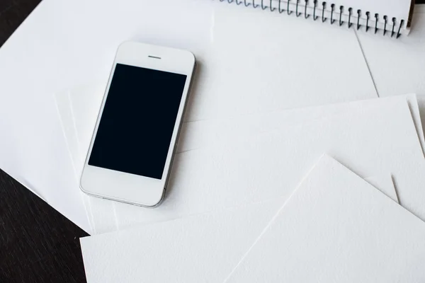 Smartphone e papel branco limpo — Fotografia de Stock