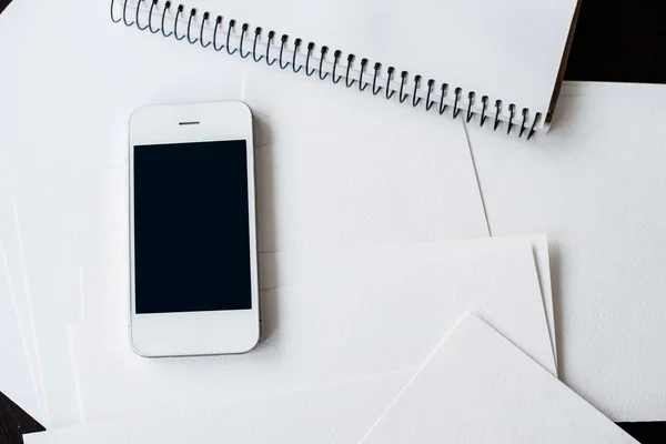 Smartphone e papel branco limpo — Fotografia de Stock