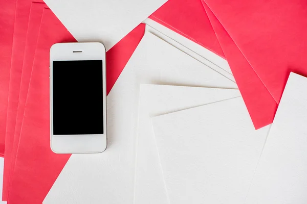 Beyaz ve kırmızı kağıt sayfalarının ile Smartphone — Stok fotoğraf