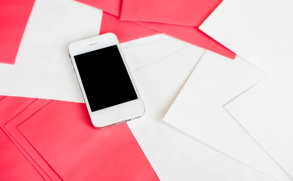 Smartphone avec feuilles de papier blanc et rouge — Photo