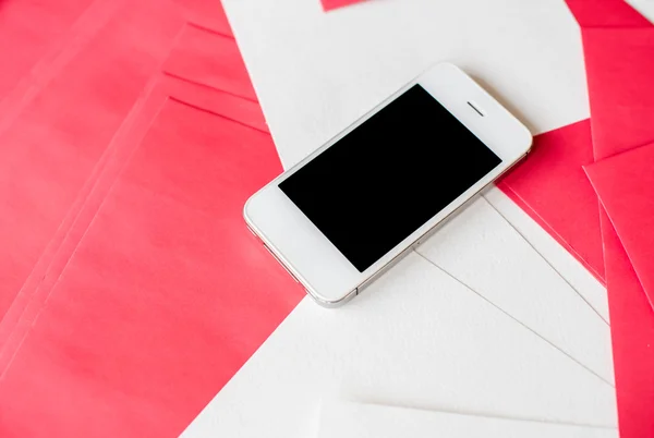 Smartphone avec feuilles de papier blanc et rouge — Photo