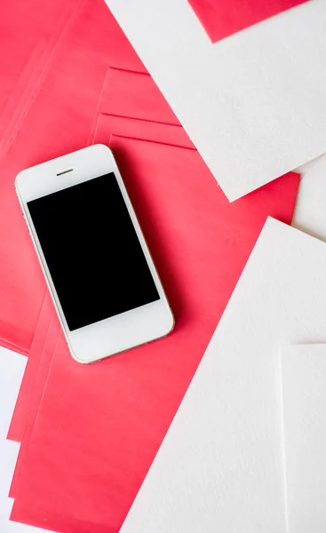 Smartphone avec feuilles de papier blanc et rouge — Photo