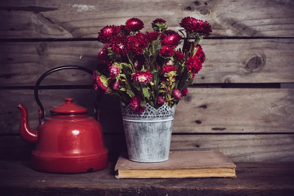 Rote Blumen und Emaille-Wasserkocher — Stockfoto