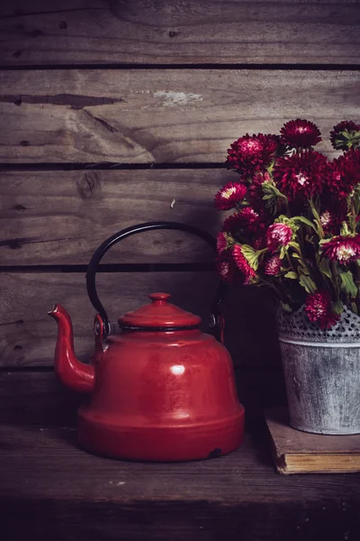 Red flowers and enamel kettle — Zdjęcie stockowe