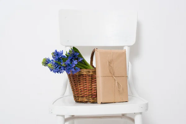 Blumen und verpacktes Geschenk — Stockfoto