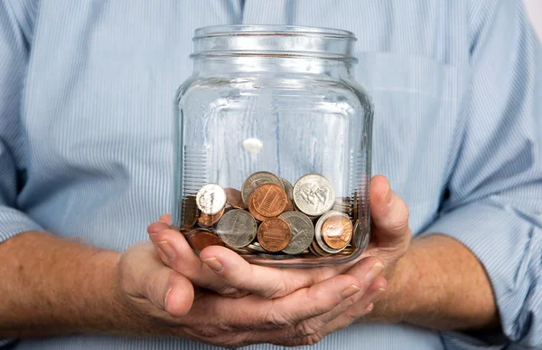 In der Hand ein Glas mit Münzgeld — Stockfoto