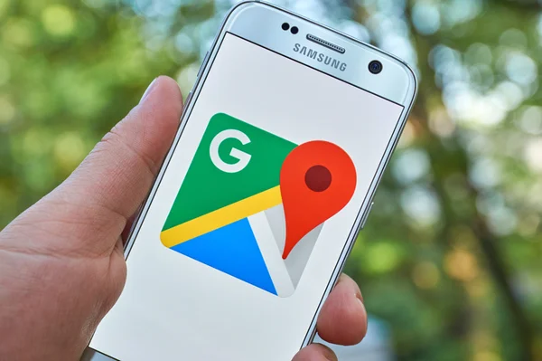 Homem mão segurando smartphone com o aplicativo de mapas do Google