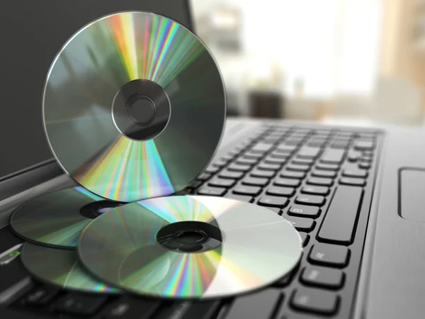 Software CD on laptop keyboard. Compact disks. — Stock Photo, Image