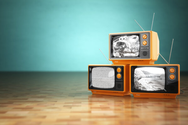 Vintage television concept. Stack of retro tv set on green backg