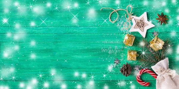 Christmas banner. Santa bag with gifts and cones on wooden green background with snow