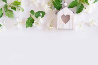 Beyaz arka planda elma çiçeği ve kuş evi