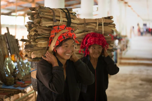 Pretty Burmese woman carrying bundles of wood — Stock Photo, Image