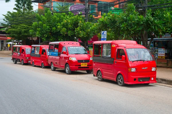 Cuatro taxis rojos estacionados en la calle . — Foto de Stock