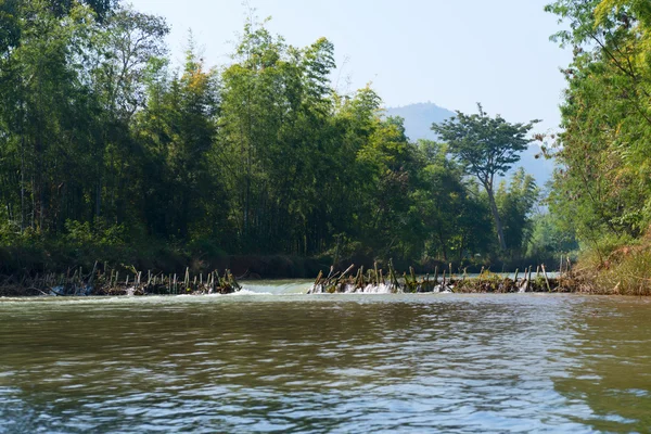 Barragem de bambu feita à mão através de um rio — Fotografia de Stock