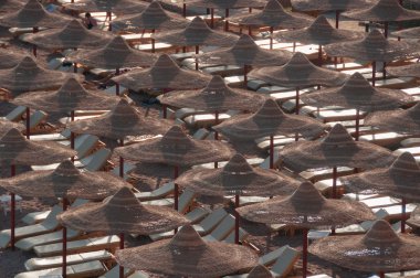 Yoğun bir tropikal plaj sandalye ve şemsiye Paketli