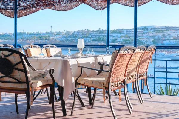 Tabelas de jantar do restaurante com vista para uma baía em um turista Tropical — Fotografia de Stock