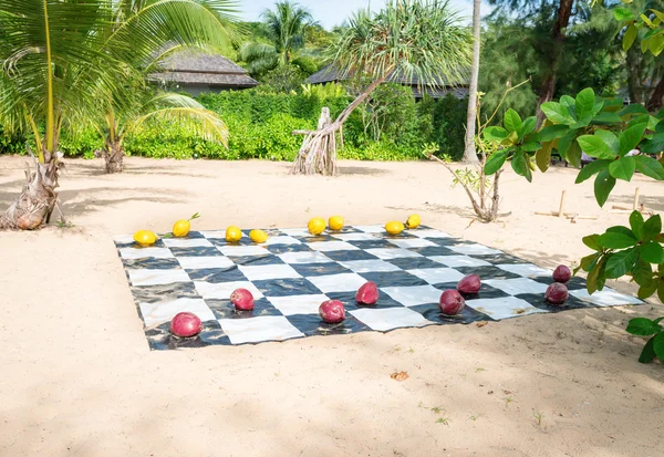 Noix de coco peintes utilisées comme vérificateurs géants sur une plage tropicale — Photo