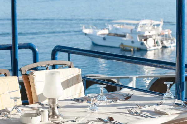 Mesa de comedor de restaurante con una vista de yates en la bahía de Imagen de archivo