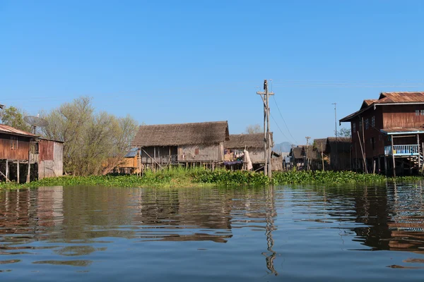 Traditionella styltor house i vatten under blå himmel — Stockfoto