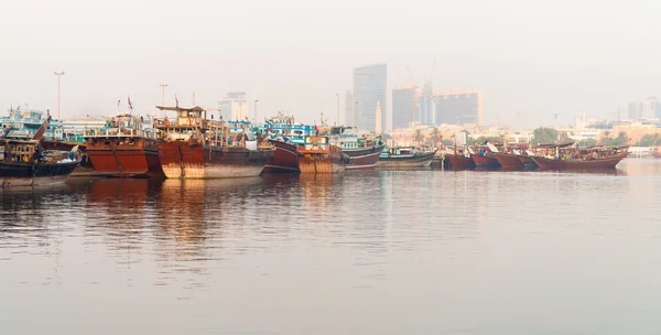 Přístavní s velké dřevěné lodě v moderním městě — Stock fotografie