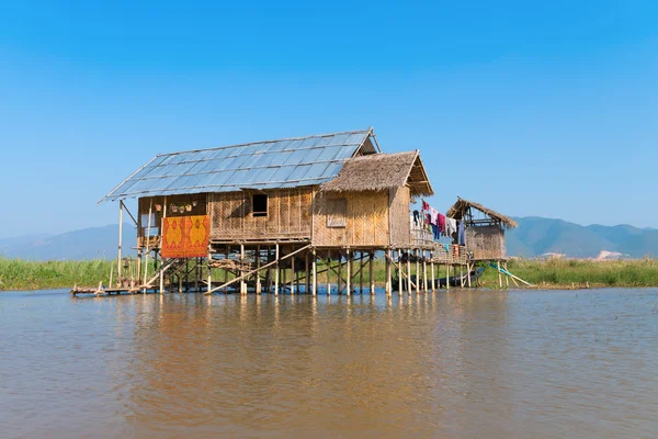 Casa de stilts tradicional em água abaixo do céu azul — Fotografia de Stock