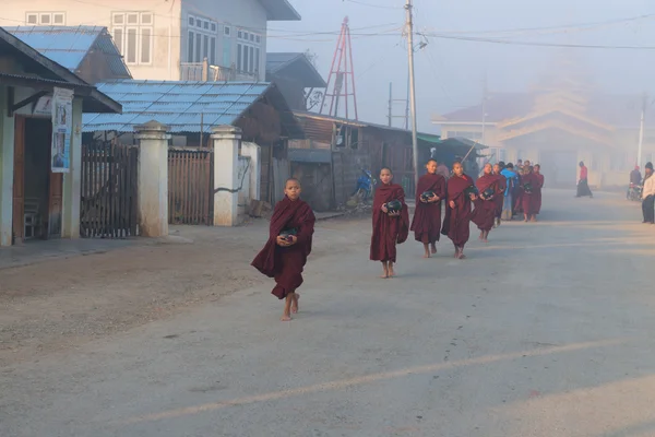 Young monks get food offerings in early morning — Stock Photo, Image