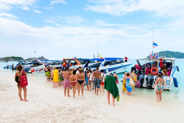 Turister gå ombord på hastighet båten på stranden — Stockfoto