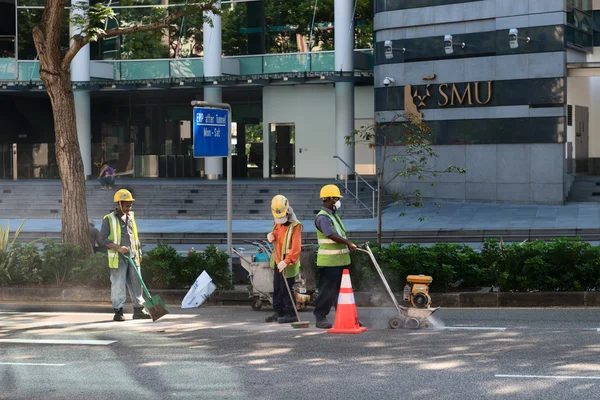 Trabajadores de la construcción reparan pavimento en una calle del centro . — Foto de Stock