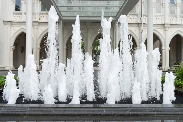 Ett flertal vertikala strålar av vatten från en utsmyckad fontän — Stockfoto