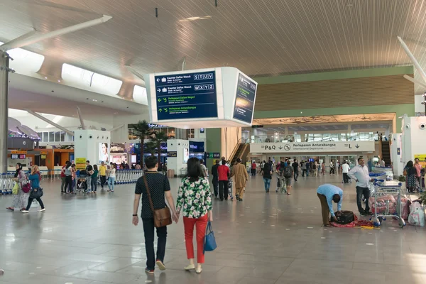 Пассажиры, прибывающие в зону международных вылетов в Куале — стоковое фото