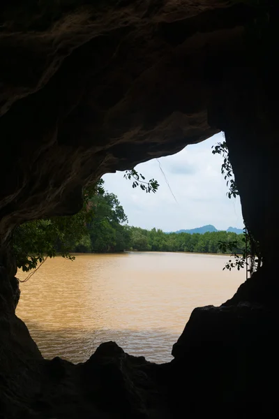 Felhős ég folyón egy sáros a belsejében egy barlang — Stock Fotó