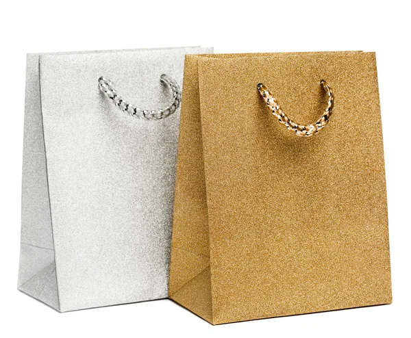 Золотые и серебряные подарочные пакеты на белом фоне — стоковое фото