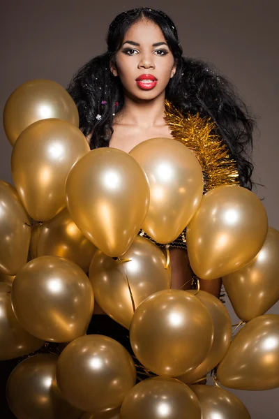 Женщина со многими золотыми шариками — стоковое фото