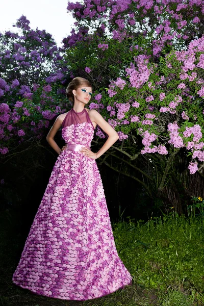 Beautiful fashionable woman in a garden — Stock Photo, Image