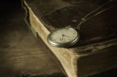 Tahta bir masanın üzerinde eski bir antika kitap.