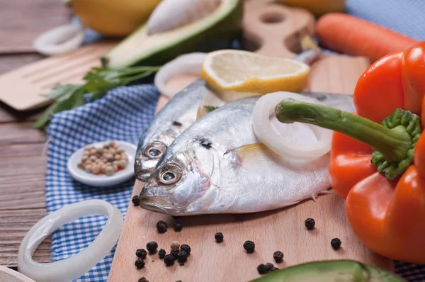 Peixe na placa de cozinha de madeira — Fotografia de Stock