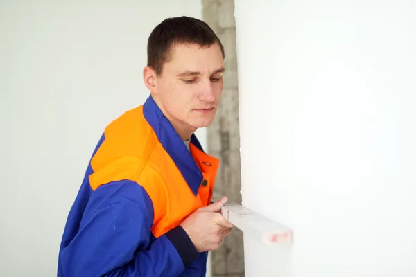 Young worker with level — Stock Photo, Image