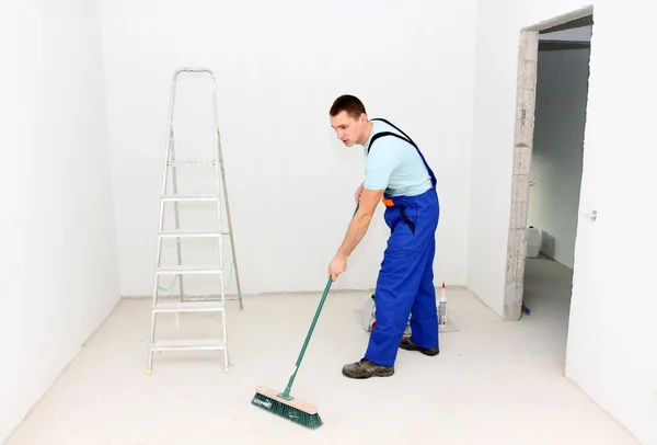 Joven limpiando una habitación después de la reparación — Foto de Stock