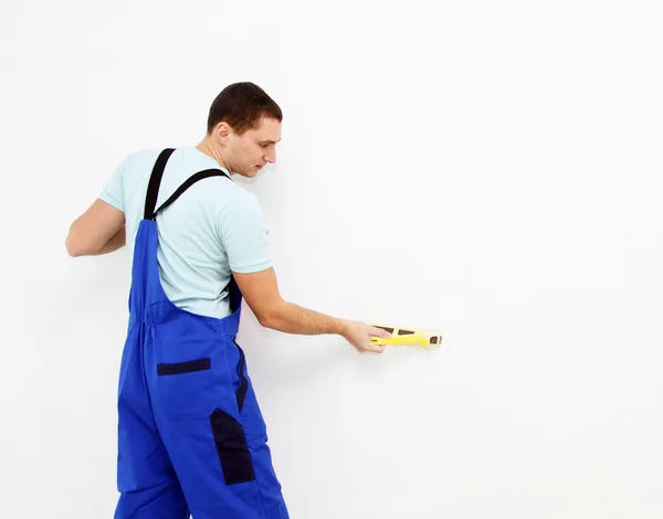 Male plasterer in uniform polishing the wall — Stock Photo, Image