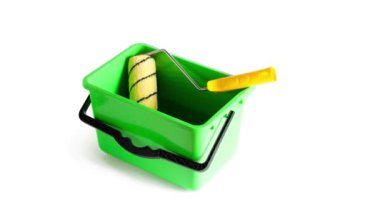 Yeşil plastik kovada boya rulosu. Yakın plan. Beyaz arkaplan üzerinde izole edilmiş.