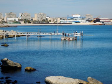 Demir bir bölümü yüzen bir platforma yüklüyorum. İskelenin inşaatı. Kazakistan. Aktau şehri. 08 Ekim 2019. Koruyucu ekipmanlar olmadan çalış.