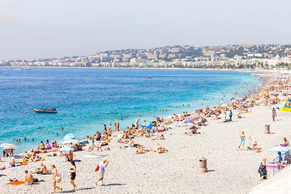 Turisté mají dobré počasí na pláži v Nice, Francie — Stock fotografie