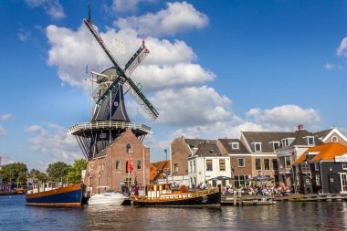 Haarlem, Hollanda - 1 Eylül 2012: Limandaki tipik yel değirmeni ve ortaçağ mimarisi. De Adriaan olarak bilinen yel değirmeni hala çalışıyor.