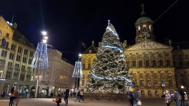 Amsterdam, Hollanda - 03 Ocak 2019: Noel için Baraj meydanında yürüyen insanlar. Ağaç geleneksel olarak Kraliyet Sarayı 'nın önüne konur..