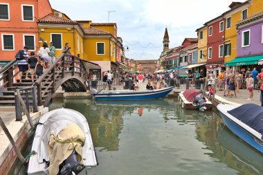 Burano, İtalya - 05 Ağustos 2016: Köyde yürüyen insanlar. Venedik yakınlarındaki ada renkli boyalı evleri ve el yapımı bağcıklarıyla ünlüdür..