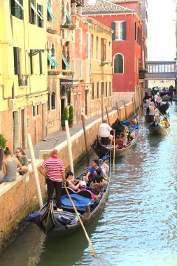 Venedik, İtalya - 5 Ağustos 2016: Kanalda gondolların tadını çıkaran turistler. Gondollar şehirdeki en popüler ve romantik ulaşım araçlarıdır..