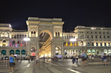 Milan, İtalya - 13 Ağustos 2016: Duomo Meydanı 'nda gece boyunca Vittorio Emmanuil II galerisinin yanında yürüyen insanlar. Alışveriş merkezi mağazaları, restoranları ve otelleriyle ünlüdür..